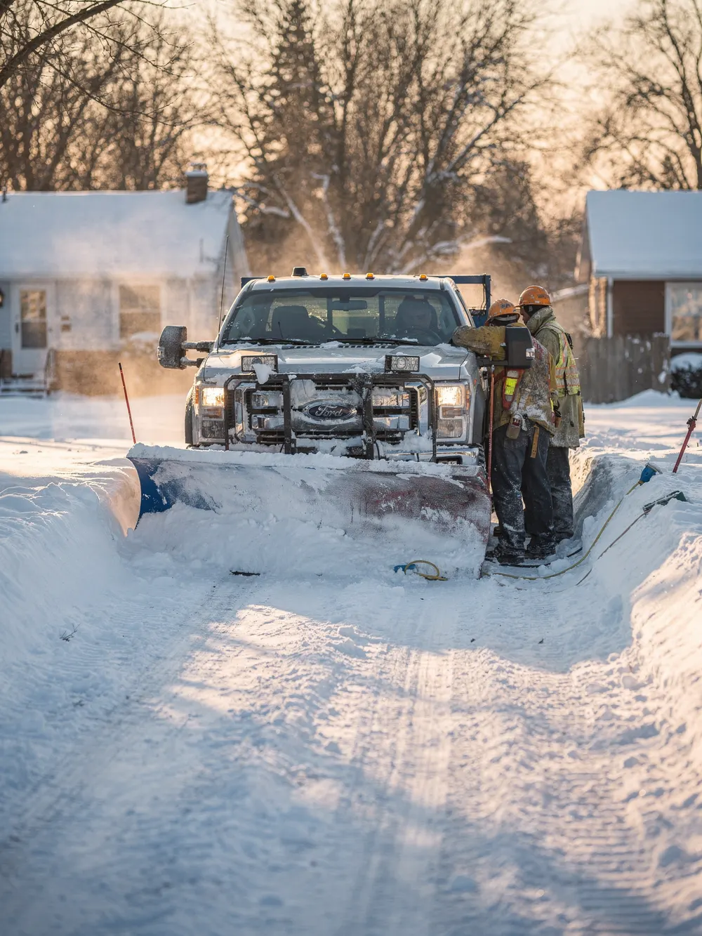 Pickup truck with a plow clearing a snowy driveway